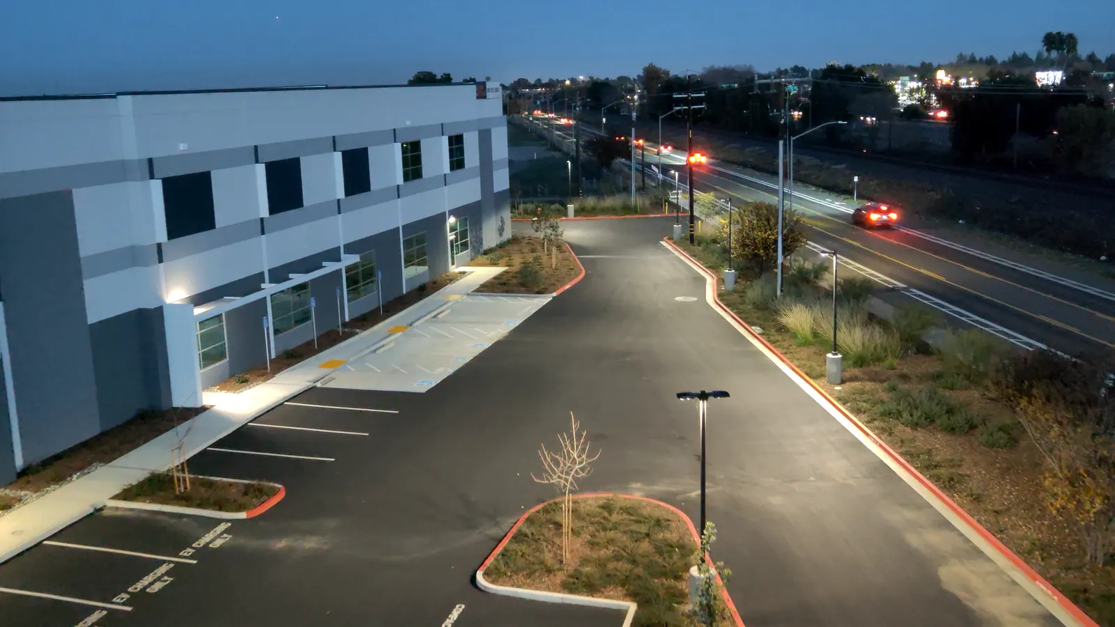 A building and road at dusk, seen from above