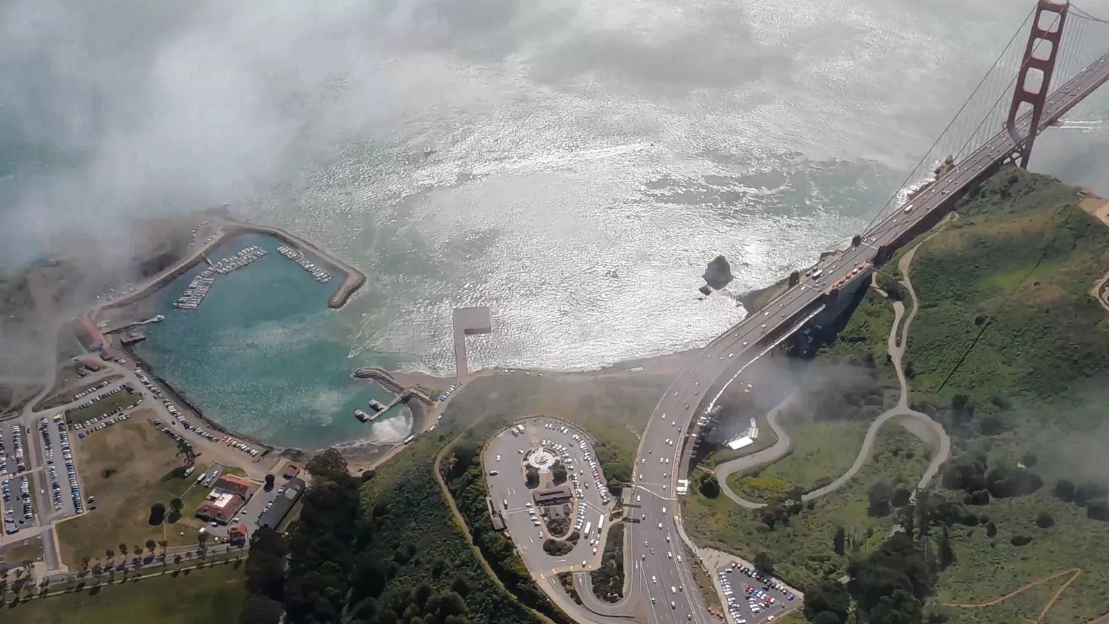 The Golden Gate Bridge emerging from fog, seen from above